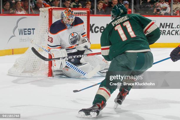 Cam Talbot of the Edmonton Oilers makes a save against Zach Parise of the Minnesota Wild during the game at the Xcel Energy Center on April 2, 2018...