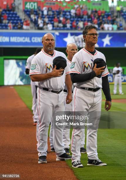 Don Mattingly and Fredi Gonzalez of the Miami Marlins stand during the National Anthem before the game against the Boston Red Sox at Marlins Park on...