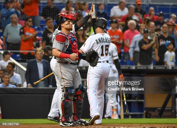 Brian Anderson of the Miami Marlins celebrates with teammates at home plate after hitting his first major league home run in the second inning...