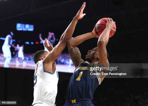 Charles Matthews of the Michigan Wolverines shoots against Phil Booth of the Villanova Wildcats in the first half during the 2018 NCAA Men's Final...