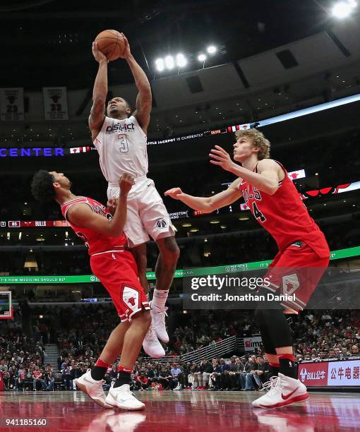 Bradley Beal of the Washington Wizards goes up for a shot between Cameron Payne and Lauri Markkanen of the Chicago Bulls at the United Center on...