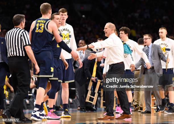 Head coach John Beilein of the Michigan Wolverines reaches the hand of Moritz Wagner of the Michigan Wolverines during a timeout during the first...