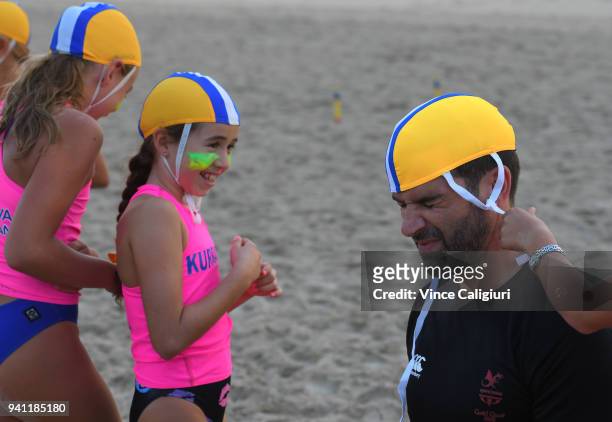 Welsh Television presenter, Gethin Jones is helped putting on his cap by Kurrawa Surf Life Saving nippers ahead of the 2018 Gold Coast Commonwealth...