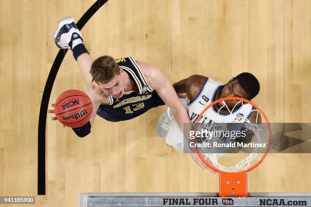 Moritz Wagner of the Michigan Wolverines shoots against Eric Paschall of the Villanova Wildcats in the first half during the 2018 NCAA Men's Final...
