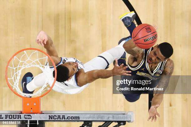 Charles Matthews of the Michigan Wolverines shoots against Phil Booth of the Villanova Wildcats in the first half during the 2018 NCAA Men's Final...