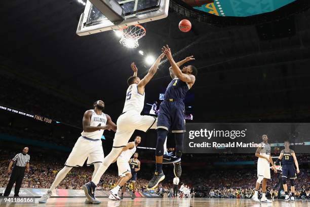 Charles Matthews of the Michigan Wolverines shoots against Phil Booth of the Villanova Wildcats in the first half during the 2018 NCAA Men's Final...