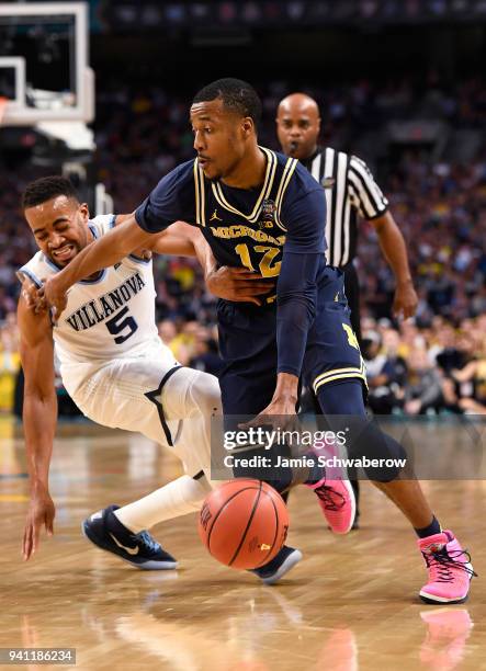 Muhammad-Ali Abdur-Rahkman of the Michigan Wolverines drive past Phil Booth of the Villanova Wildcats during the first half of the 2018 NCAA Photos...