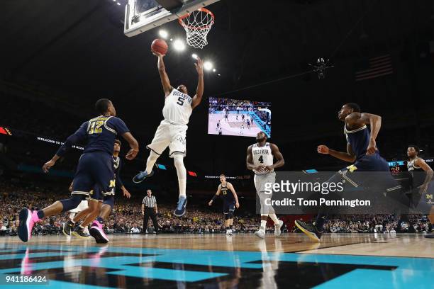 Phil Booth of the Villanova Wildcats drives to the basket against Muhammad-Ali Abdur-Rahkman of the Michigan Wolverines in the first half during the...