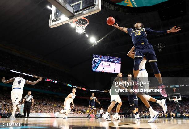 Muhammad-Ali Abdur-Rahkman of the Michigan Wolverines drives to the basket against Jalen Brunson of the Villanova Wildcats in the first half during...