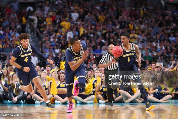 Charles Matthews of the Michigan Wolverines brings the ball up the court with teammates Isaiah Livers and Muhammad-Ali Abdur-Rahkman against the...