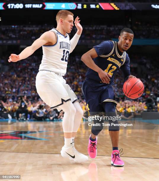 Muhammad-Ali Abdur-Rahkman of the Michigan Wolverines is defended by Donte DiVincenzo of the Villanova Wildcats in the first half during the 2018...