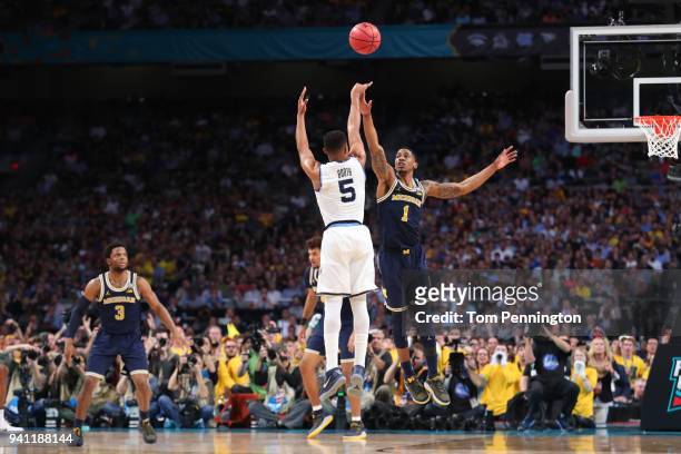 Phil Booth of the Villanova Wildcats attempts a shot defended by Charles Matthews of the Michigan Wolverines in the first half during the 2018 NCAA...