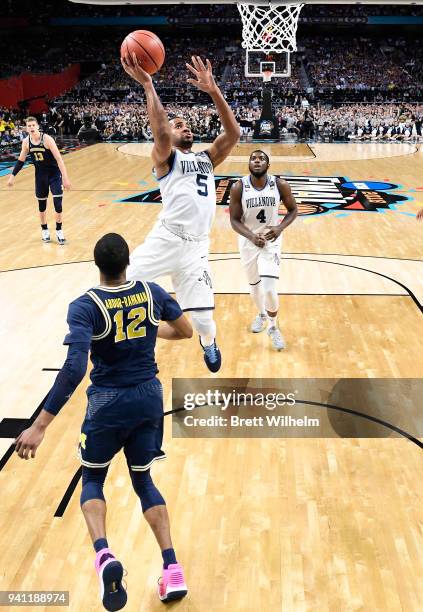 Phil Booth of the Villanova Wildcats drives to the basket against Muhammad-Ali Abdur-Rahkman of the Michigan Wolverines during the first half of the...