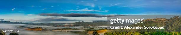 tuscany hills covered by morning fog, autumnal colors of nature. italy. - agriturismo stock-fotos und bilder