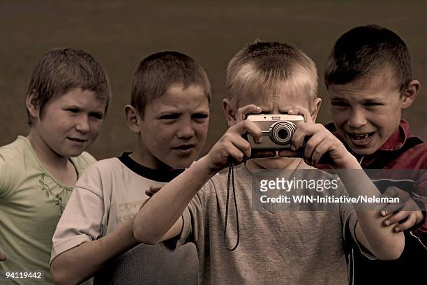 boy taking a picture with his friends standing behind him, komarivka, odessa oblast, ukraine - historical geopolitical location fotografías e imágenes de stock