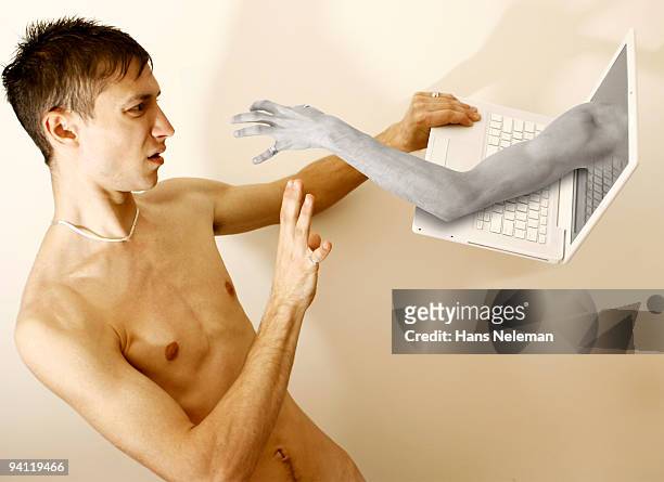 hand emerging from a laptop and scaring a man, republic of ireland - technofobie stockfoto's en -beelden
