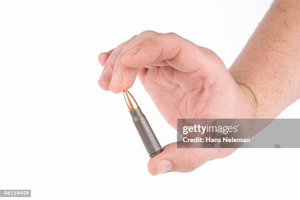 close-up of a person's hand holding a bullet - caliber stock pictures, royalty-free photos & images