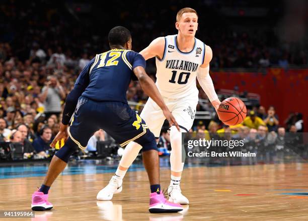 Donte DiVincenzo of the Villanova Wildcats driblles against Muhammad-Ali Abdur-Rahkman of the Michigan Wolverines during the first half of the 2018...