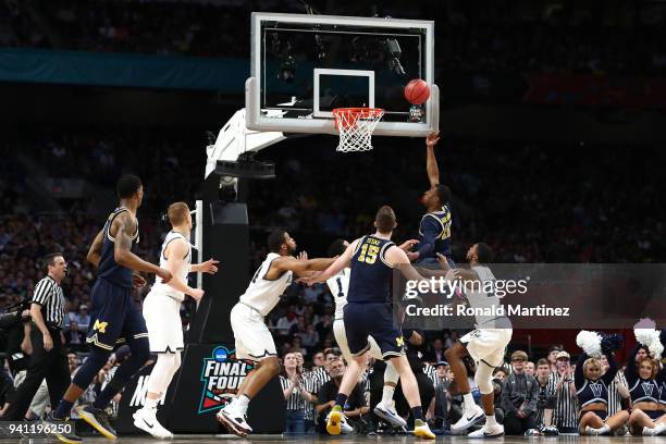 Muhammad-Ali Abdur-Rahkman of the Michigan Wolverines drives to the basket against Mikal Bridges of the Villanova Wildcats in the first half during...