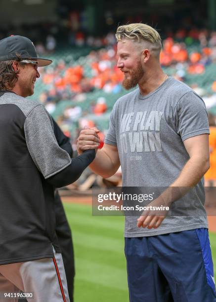 Baltimore Orioles right fielder Colby Rasmus chats with Houston Astros relief pitcher Chris Devenski before the MLB game between the Baltimore...