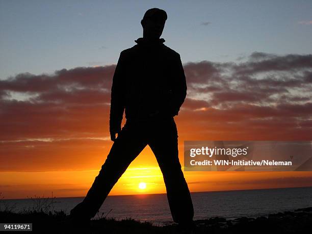 silhouette of a man standing on the beach, el tabo, chile - breitbeinig stehen stock-fotos und bilder
