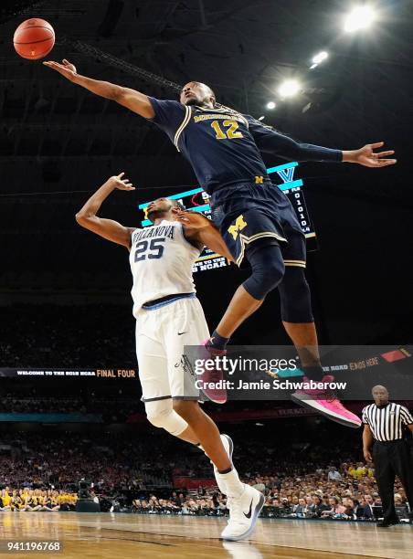 Muhammad-Ali Abdur-Rahkman of the Michigan Wolverines drives to the basket against Mikal Bridges of the Villanova Wildcats in the first half in the...