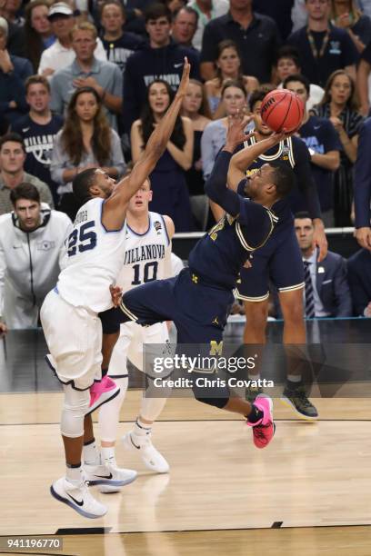 Muhammad-Ali Abdur-Rahkman of the Michigan Wolverines attempts a shot against Mikal Bridges of the Villanova Wildcats in the first half during the...