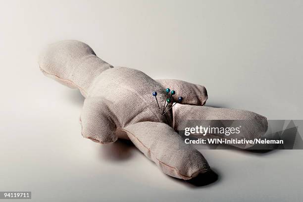 close-up of a voodoo doll with straight pins on its crotch - zona inguinale foto e immagini stock
