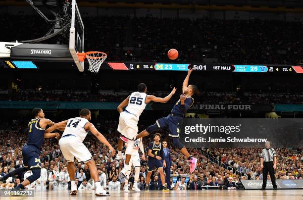 Muhammad-Ali Abdur-Rahkman of the Michigan Wolverines shoots the ball over Mikal Bridges of the Villanova Wildcats during the first half of the 2018...