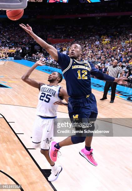 Muhammad-Ali Abdur-Rahkman of the Michigan Wolverines drives to the basket against Mikal Bridges of the Villanova Wildcats during the first half of...