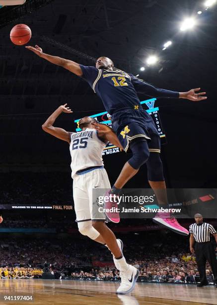 Muhammad-Ali Abdur-Rahkman of the Michigan Wolverines drives to the basket against Mikal Bridges of the Villanova Wildcats during the first half of...