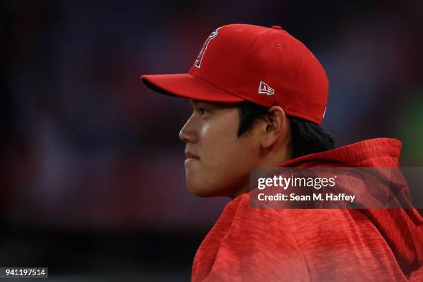 Shohei Ohtani of the Los Angeles Angels of Anaheim looks on from the dugout during the first inning of the home opening game against the Cleveland...