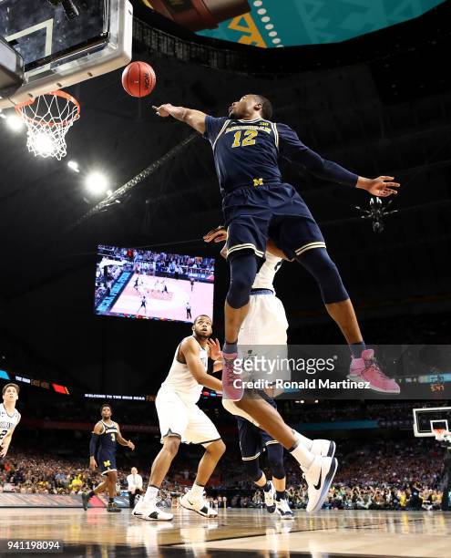 Muhammad-Ali Abdur-Rahkman of the Michigan Wolverines drives to the basket against Mikal Bridges of the Villanova Wildcats in the first half in the...