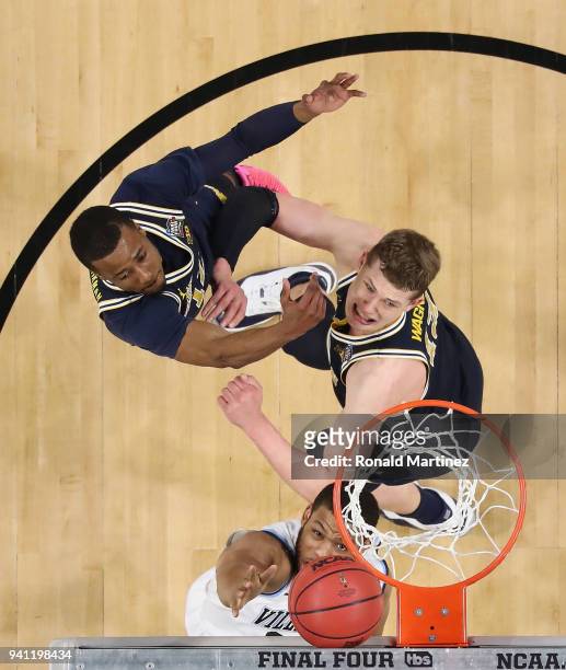 Omari Spellman of the Villanova Wildcats competes for the ball with Muhammad-Ali Abdur-Rahkman and Moritz Wagner of the Michigan Wolverines in the...