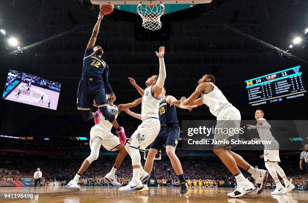 Muhammad-Ali Abdur-Rahkman of the Michigan Wolverines drives to the basket agasinst Jalen Brunson of the Villanova Wildcats during the first half of...