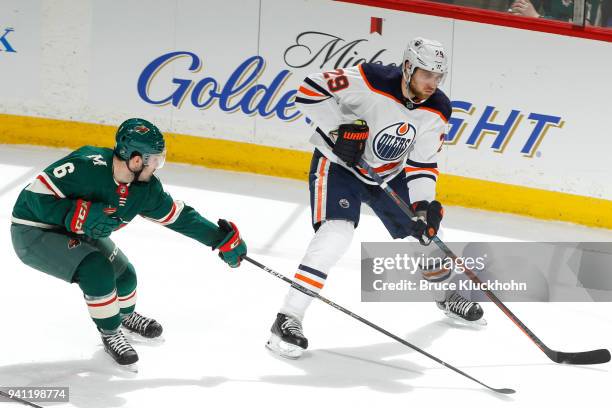 Leon Draisaitl of the Edmonton Oilers skates with the puck while Ryan Murphy of the Minnesota Wild defends during the game at the Xcel Energy Center...