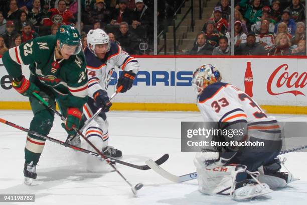 Cam Talbot defend his goal while his teammate Ethan Bear of the Edmonton Oilers is called for slashing against Nino Niederreiter of the Minnesota...