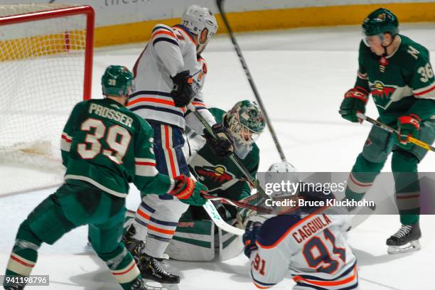 Devan Dubnyk makes a save while his teammates Nate Prosser and Nick Seeler of the Minnesota Wild defend against Milan Lucic and Drake Caggiula of the...