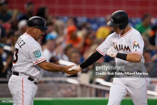 Brian Anderson of the Miami Marlins shakes hands with Fredi Gonzalez of the Miami Marlins after hitting his first career home run during the second...