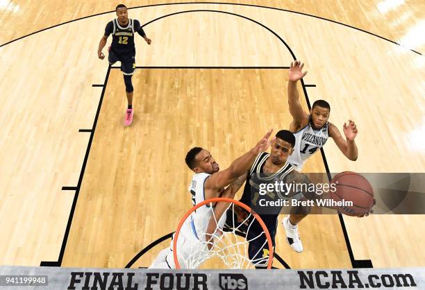 Charles Matthews of the Michigan Wolverines drives to the basket against Phil Booth of the Villanova Wildcats during the second half of the 2018 NCAA...