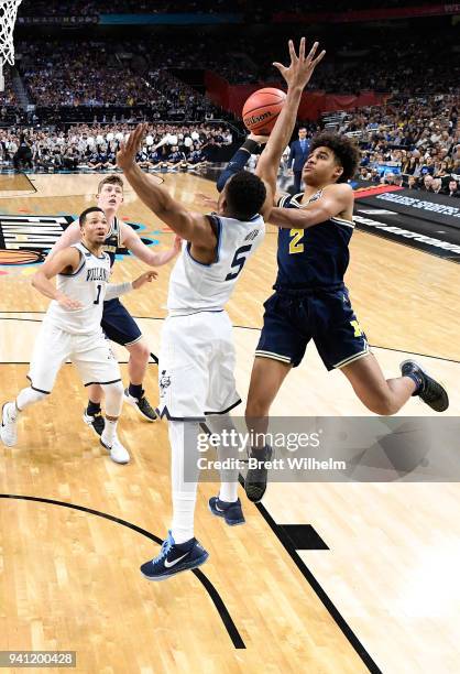 Jordan Poole of the Michigan Wolverines drives to the basket against Phil Booth of the Villanova Wildcats during the second half of the 2018 NCAA...