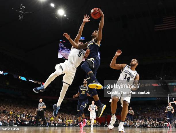 Charles Matthews of the Michigan Wolverines attempts a shot against Phil Booth of the Villanova Wildcats in the second half during the 2018 NCAA...
