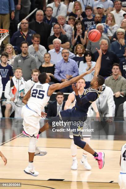 Muhammad-Ali Abdur-Rahkman of the Michigan Wolverines attempts a shot against Mikal Bridges of the Villanova Wildcats in the first half in the 2018...