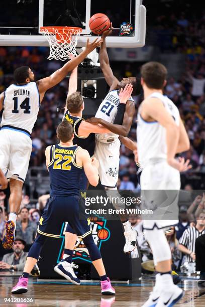 Dhamir Cosby-Roundtree and Omari Spellman of the Villanova Wildcats compete for the ball against Moritz Wagner of the Michigan Wolverines during the...