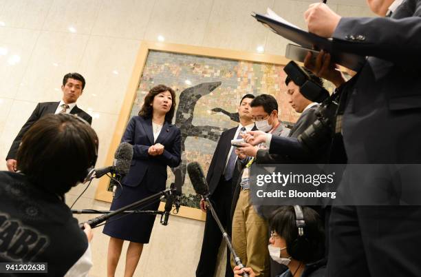 Seiko Noda, Japan's internal affairs and communications minister, second left, speaks to members of the media at the opening day of her school for...