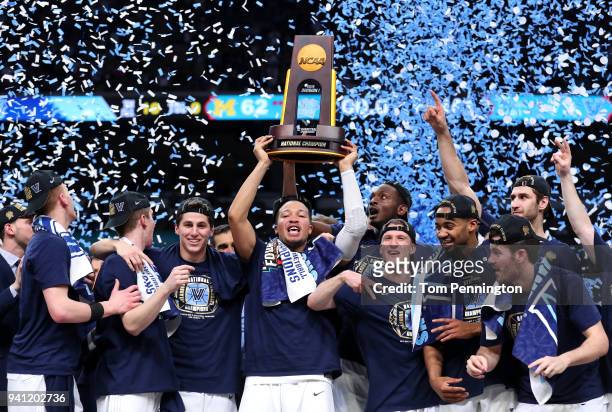 Jalen Brunson of the Villanova Wildcats raises the trophy and celebrates with his teammates after defeating the Michigan Wolverines during the 2018...