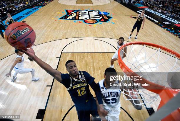 Muhammad-Ali Abdur-Rahkman of the Michigan Wolverines drives to the basket against Mikal Bridges of the Villanova Wildcats during the second half of...