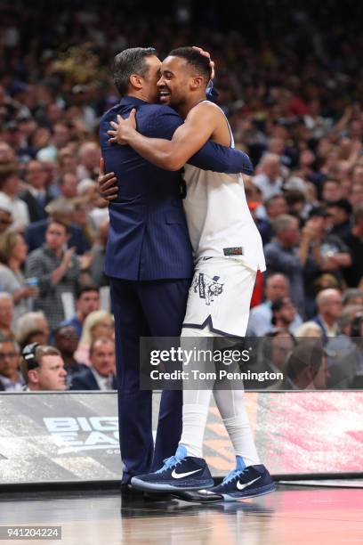 Head coach Jay Wright hugs Phil Booth of the Villanova Wildcats as he comes off the court late in the second half in his teams win over the Michigan...