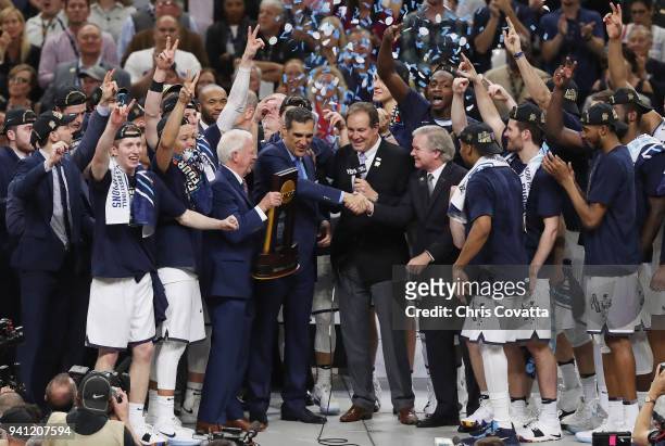 Personality Jim Nantz and NCAA President Dr. Mark Emmert speak to head coach Jay Wright of the Villanova Wildcats after defeating the Michigan...