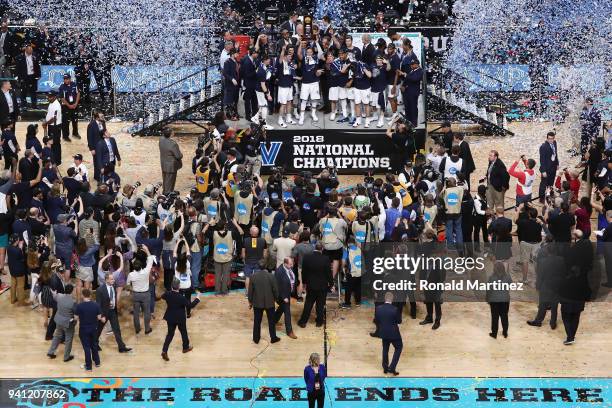 Jalen Brunson of the Villanova Wildcats raises the trophy and celebrates with his teammates after defeating the Michigan Wolverines during the 2018...